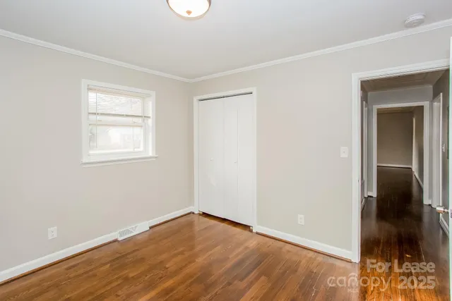 an empty room with wooden floor and closet