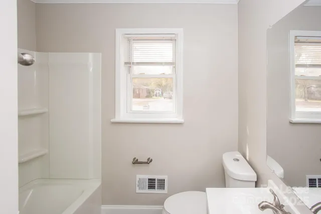 a white toilet sitting next to a bath tub