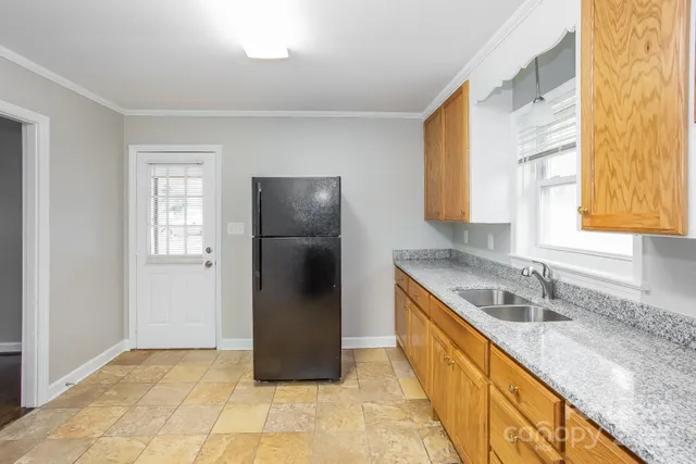 a kitchen with stainless steel appliances granite countertop a refrigerator and a sink