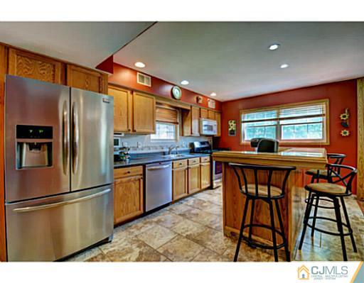 20 Kimberly Road Colonia, NJ 07067 - Photo 8 of 25 a kitchen with stainless steel appliances granite countertop a refrigerator a sink a stove and island