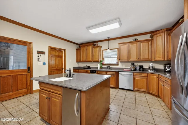 a kitchen with stainless steel appliances granite countertop a stove a sink dishwasher and a refrigerator