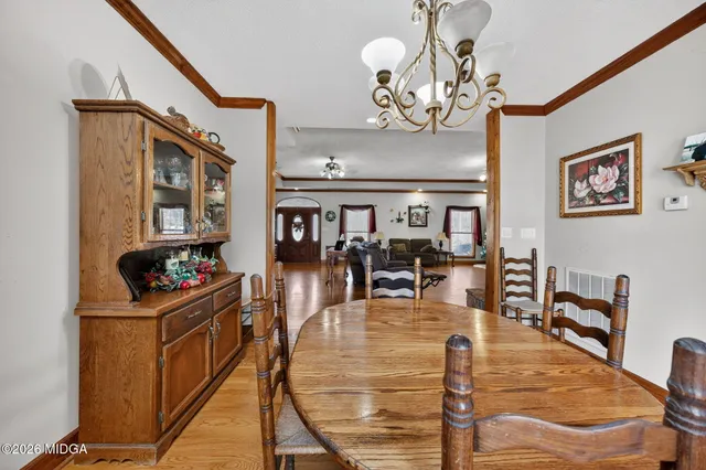 a view of a dining room with furniture a chandelier and wooden floor