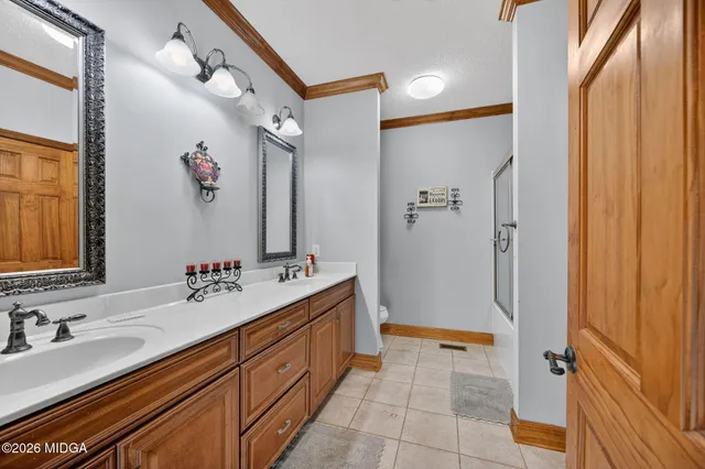 a bathroom with a double vanity sink mirror and shower