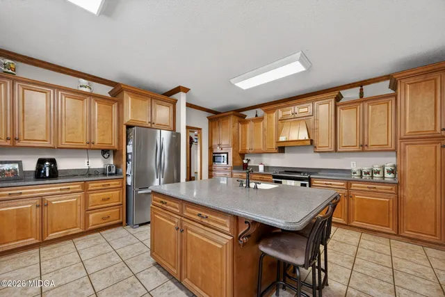 a kitchen with stainless steel appliances granite countertop a stove a sink and a refrigerator