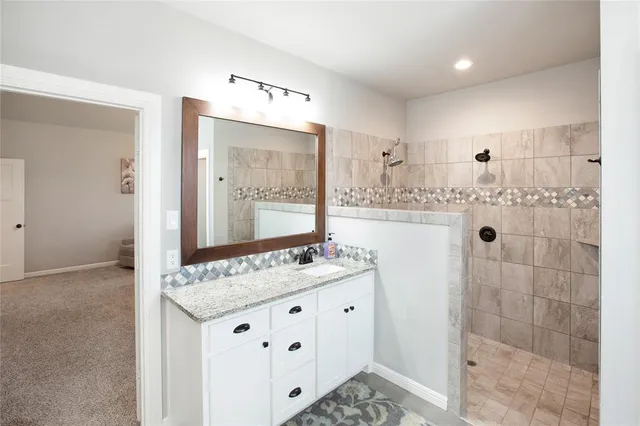 a bathroom with a double vanity sink mirror and shower
