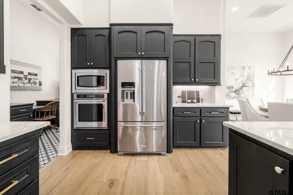 a living room with furniture kitchen view and a large window