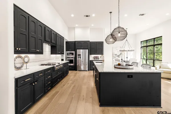 a kitchen with stainless steel appliances granite countertop a refrigerator and a stove
