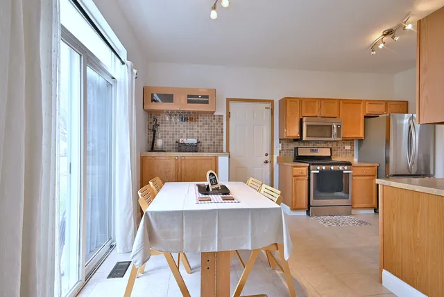 a kitchen with a table chairs refrigerator and microwave