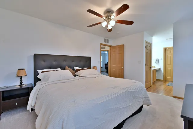a bedroom with a large bed and a chandelier