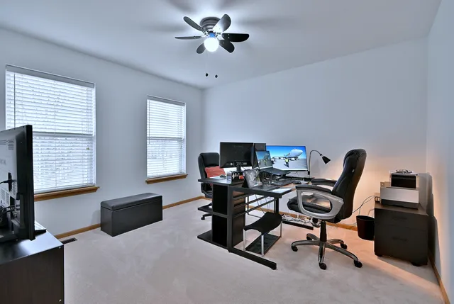 a view of a workspace with furniture and a window