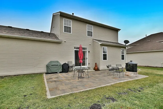 a backyard of a house with table and chairs