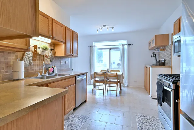 a kitchen with stainless steel appliances granite countertop a sink stove and refrigerator