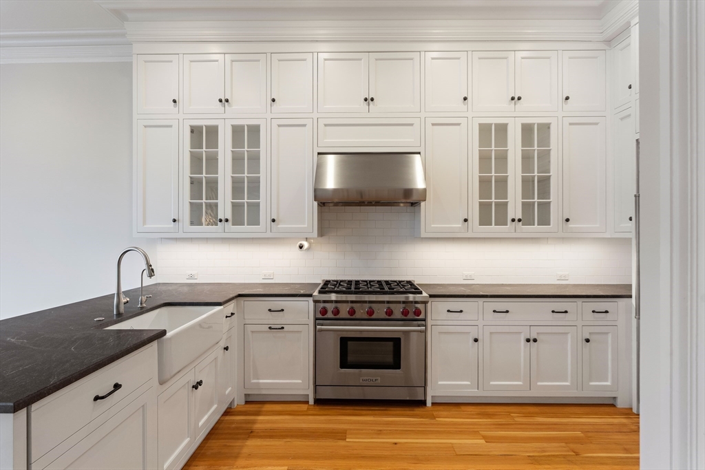 64 Commonwealth Avenue, Unit 5 Boston, MA 02116 - Photo 11 of 24 a kitchen with stainless steel appliances granite countertop a sink dishwasher a stove and a microwave oven with cabinets