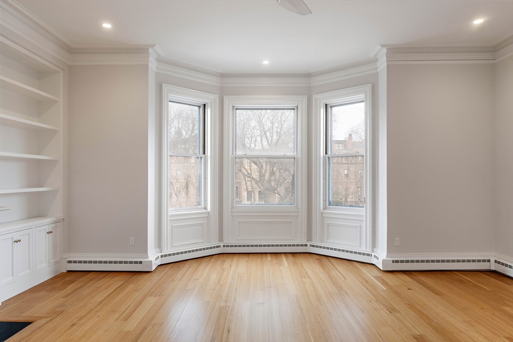 64 Commonwealth Avenue, Unit 5 Boston, MA 02116 - Photo 12 of 24 an empty room with wooden floor and windows