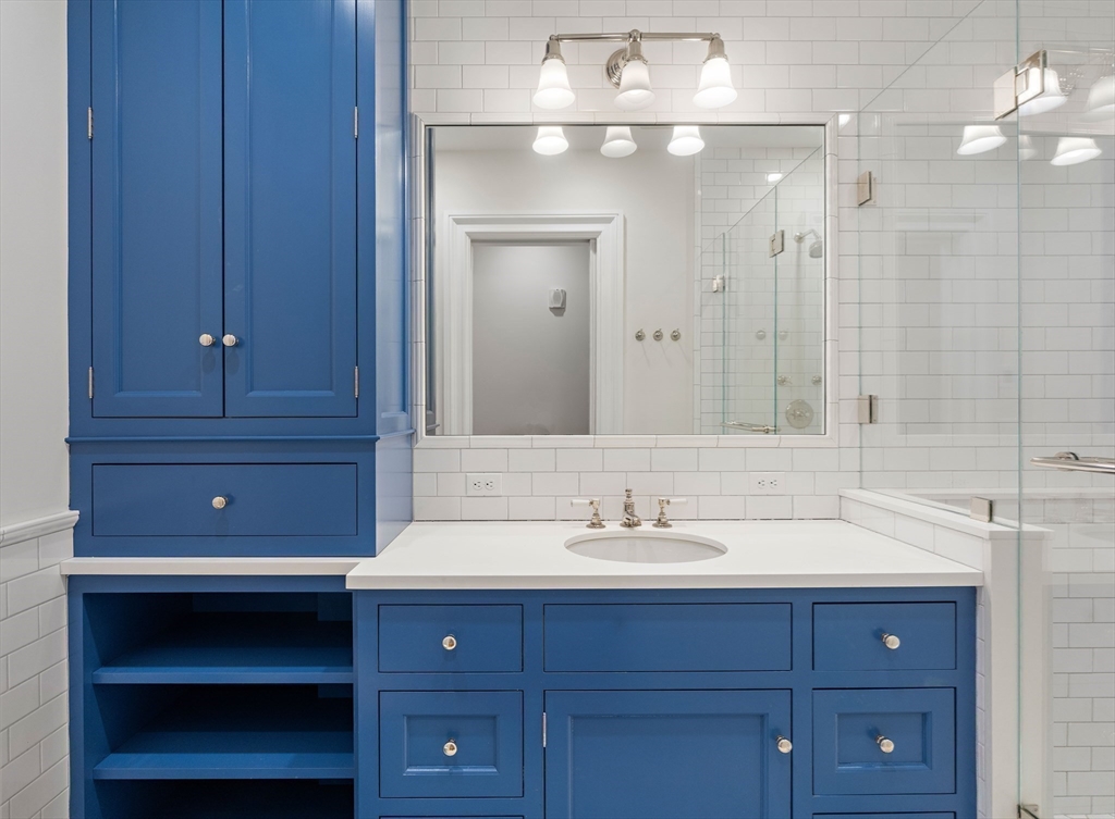 64 Commonwealth Avenue, Unit 5 Boston, MA 02116 - Photo 14 of 24 a bathroom with a sink and a mirror