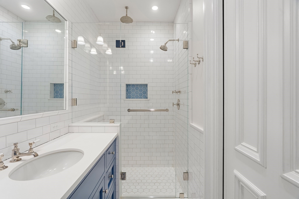 64 Commonwealth Avenue, Unit 5 Boston, MA 02116 - Photo 15 of 24 a bathroom with a granite countertop sink a shower and a mirror