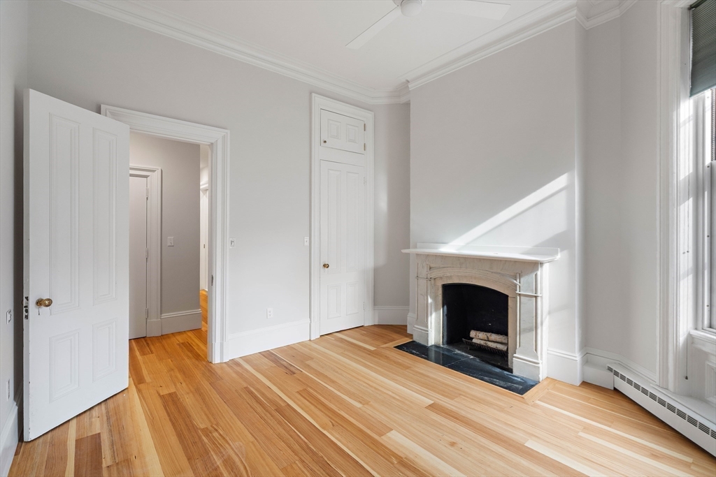 64 Commonwealth Avenue, Unit 5 Boston, MA 02116 - Photo 17 of 24 a view of empty room with wooden floor and fireplace