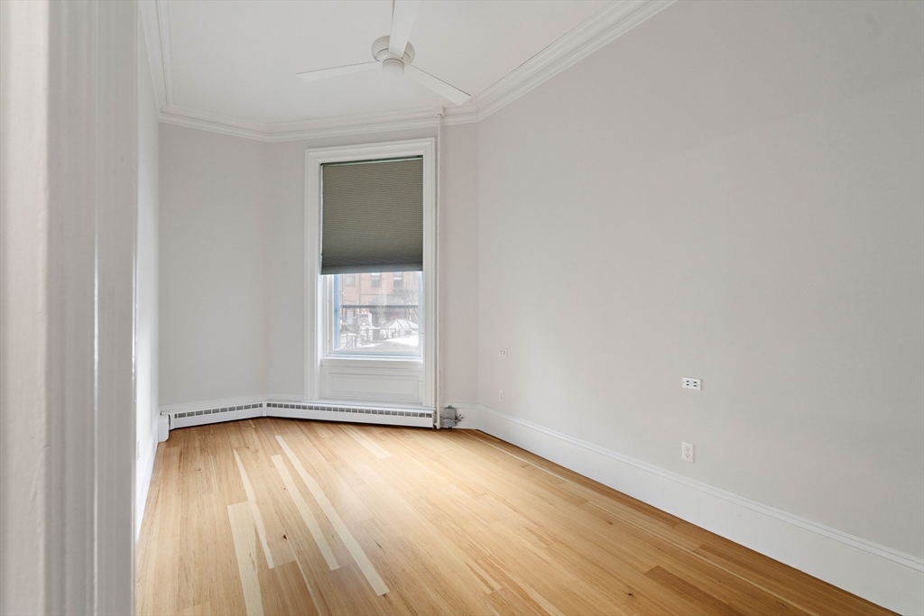 64 Commonwealth Avenue, Unit 5 Boston, MA 02116 - Photo 20 of 24 an empty room with wooden floor and windows