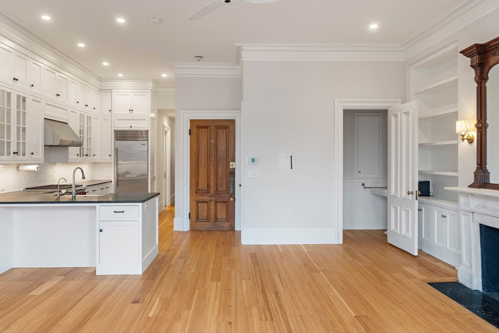64 Commonwealth Avenue, Unit 5 Boston, MA 02116 - Photo 7 of 24 a large kitchen with stainless steel appliances granite countertop a lot of counter space and wooden floor
