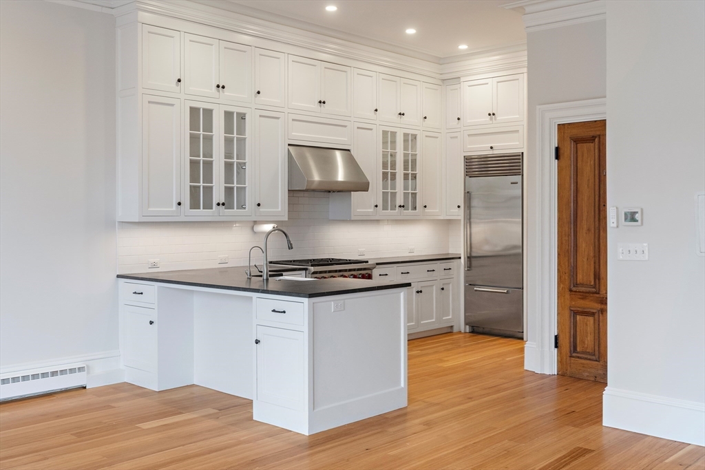 64 Commonwealth Avenue, Unit 5 Boston, MA 02116 - Photo 8 of 24 a kitchen with stainless steel appliances granite countertop a stove and a refrigerator