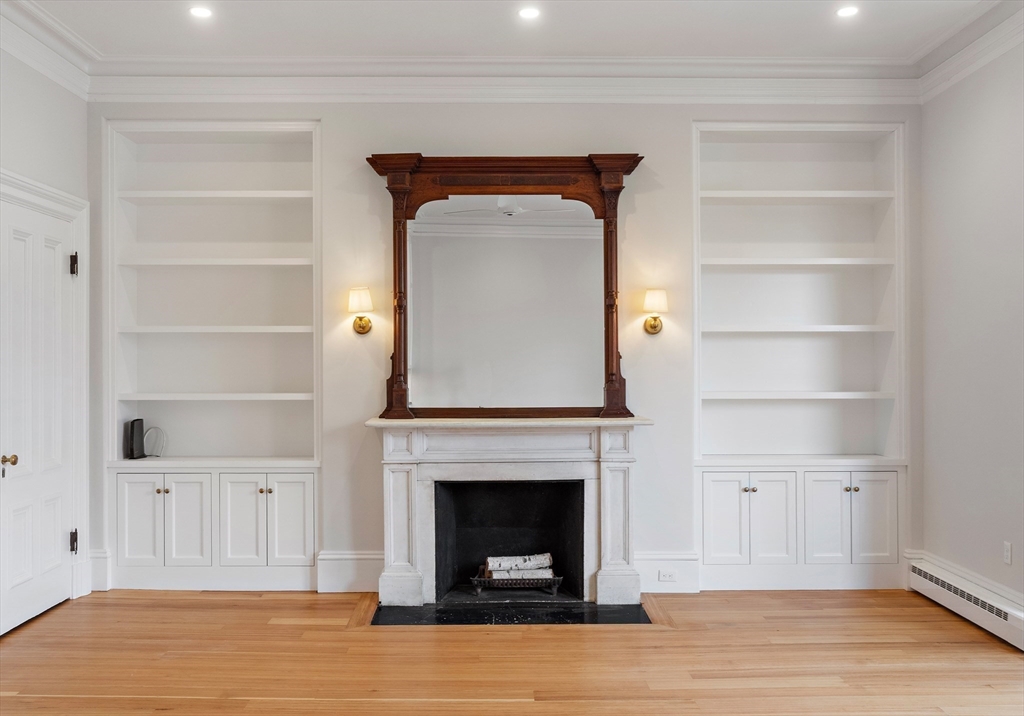 64 Commonwealth Avenue, Unit 5 Boston, MA 02116 - Photo 9 of 24 a living room with a fireplace and a wooden floor