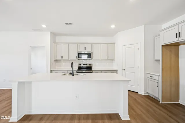 a kitchen with stainless steel appliances cabinets a sink and a refrigerator