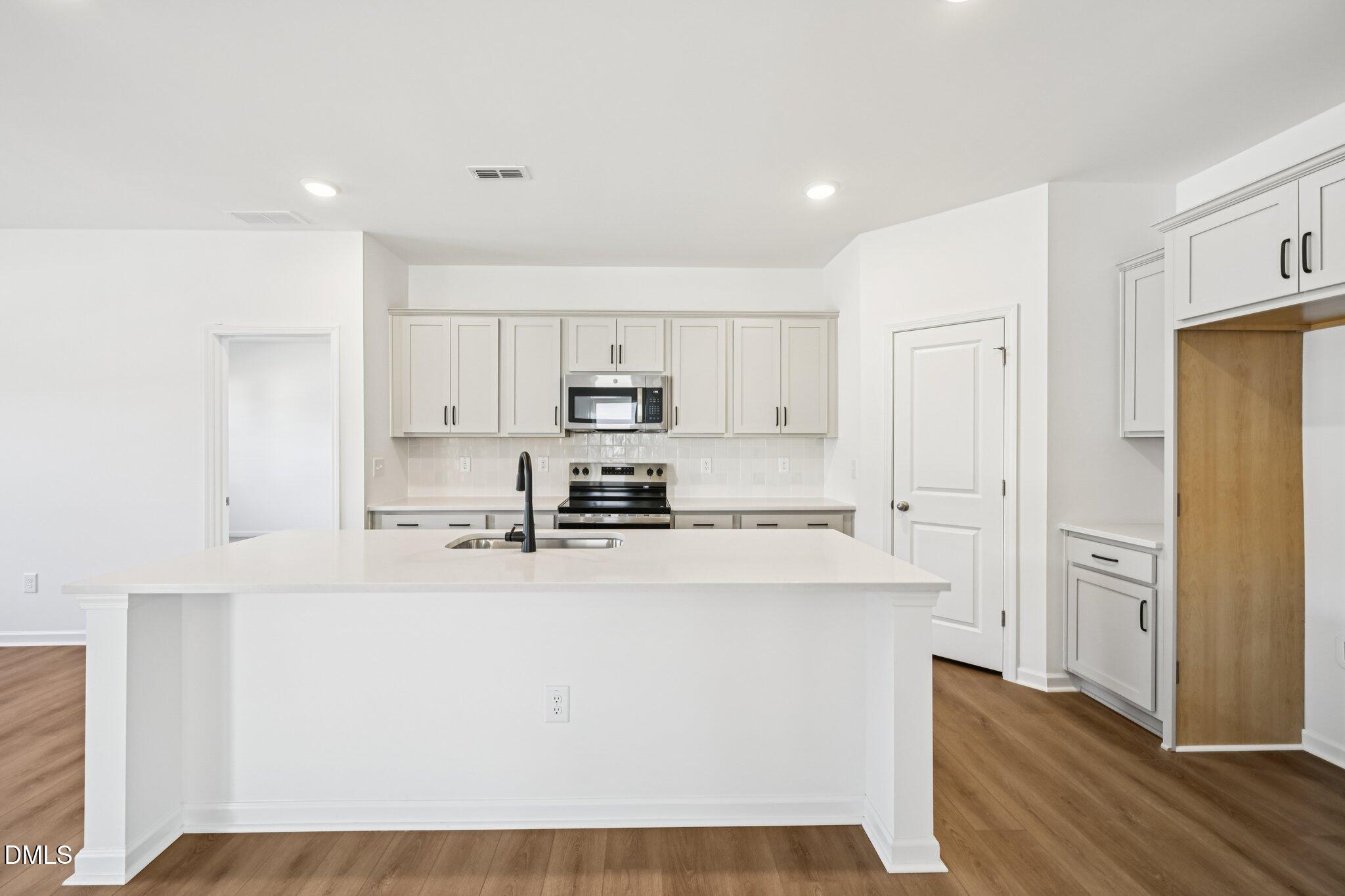 11766 Salers Loop Middlesex, NC 27557 - Photo 13 of 55 a kitchen with stainless steel appliances cabinets a sink and a refrigerator