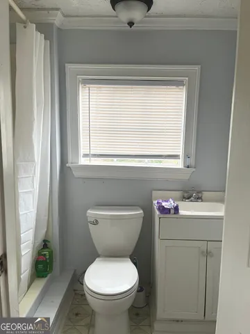 a bathroom with a toilet sink and mirror