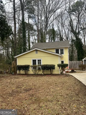 a view of house with backyard and sitting area