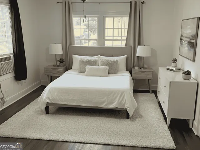 a bedroom with a bed and a flat tv screen on dresser