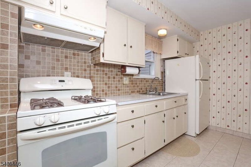 22-06 Arcadia Road Fair Lawn, NJ 07410 - Photo 7 of 33 a kitchen with white cabinets and white appliances
