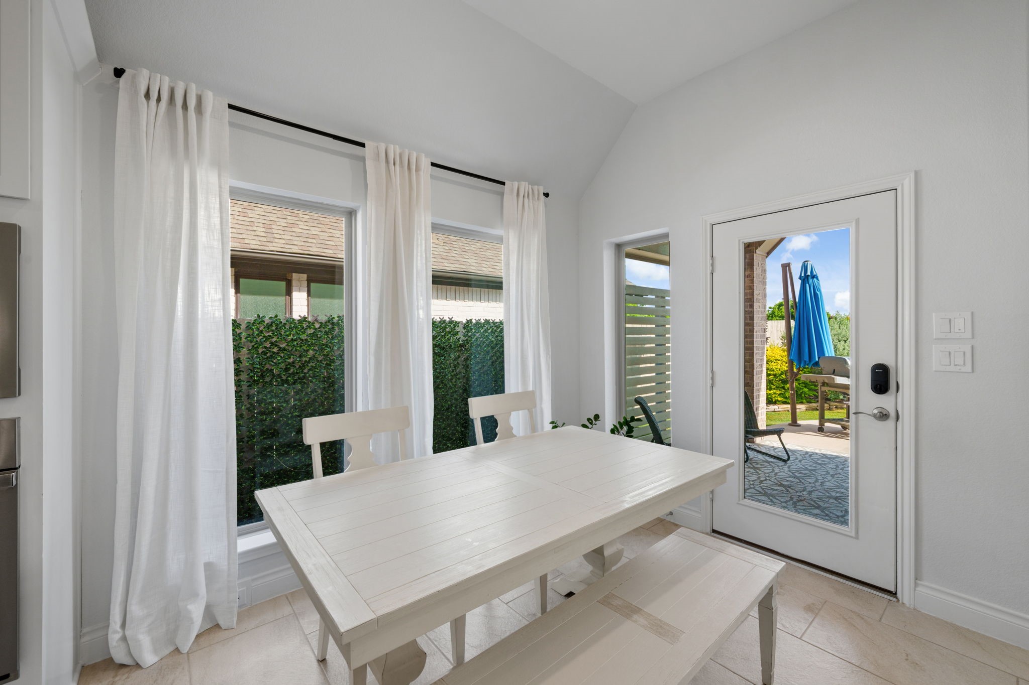 2119 Blackhawk Ridge Lane Manvel, TX 77578 - Photo 14 of 49 Breakfast Nook / Dining Area with large windows, sheer white drapes, and a glass door leading directly to the covered patio and backyard — perfect for morning coffee with a view.