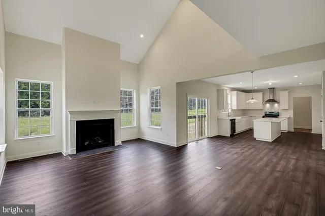 a view of a room with wooden floor and a kitchen
