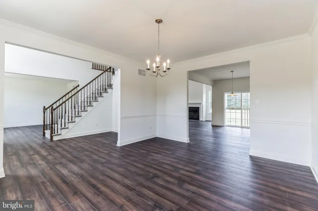 a view of a room with wooden floor and chandelier