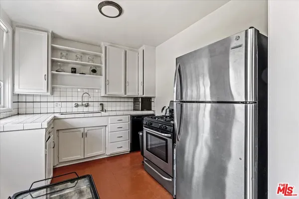 a kitchen with stainless steel appliances granite countertop a refrigerator sink and stove