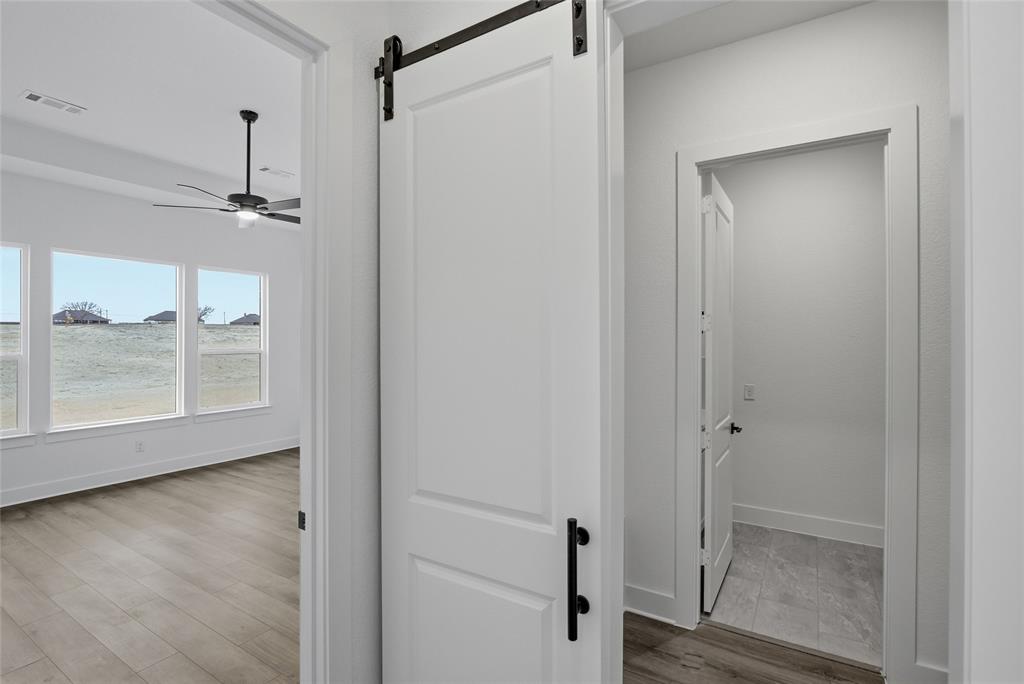 810 Vly Rdg Road Van Alstyne, TX 75495 - Photo 19 of 39 Hallway with a barn door and light wood-style flooring