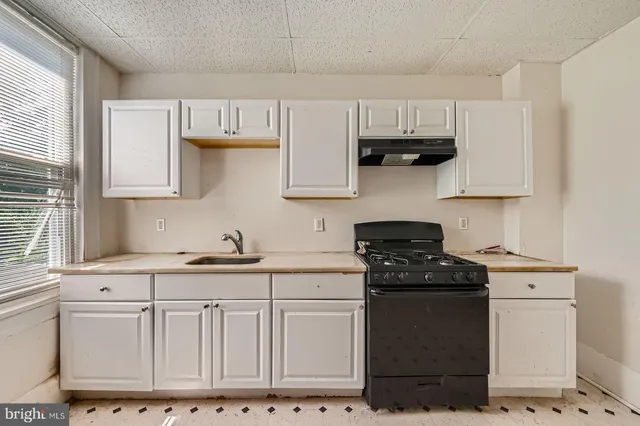 a kitchen with granite countertop white cabinets and stainless steel appliances