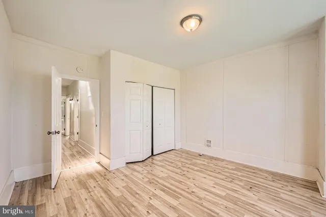 a view of empty room with wooden floor