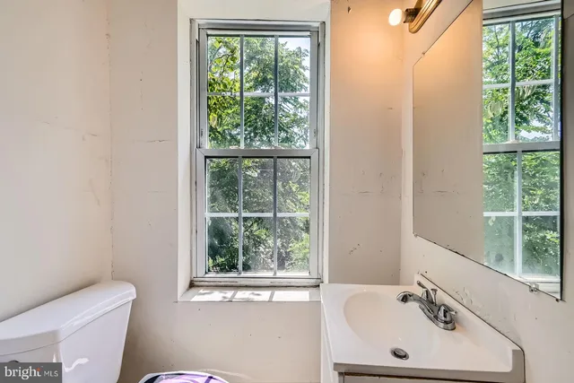 a bathroom with a sink a toilet and a window