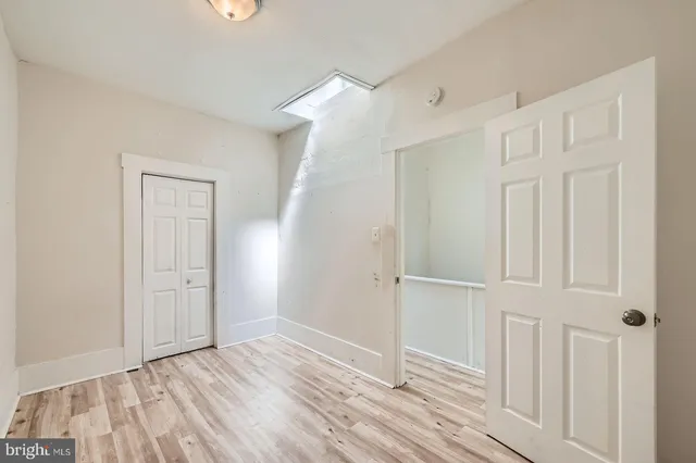 an empty room with wooden floor and closet area