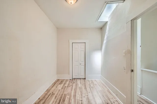 a view of a small space with wooden floor and a window