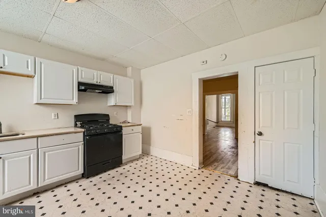 a kitchen with granite countertop a sink and a stove top oven