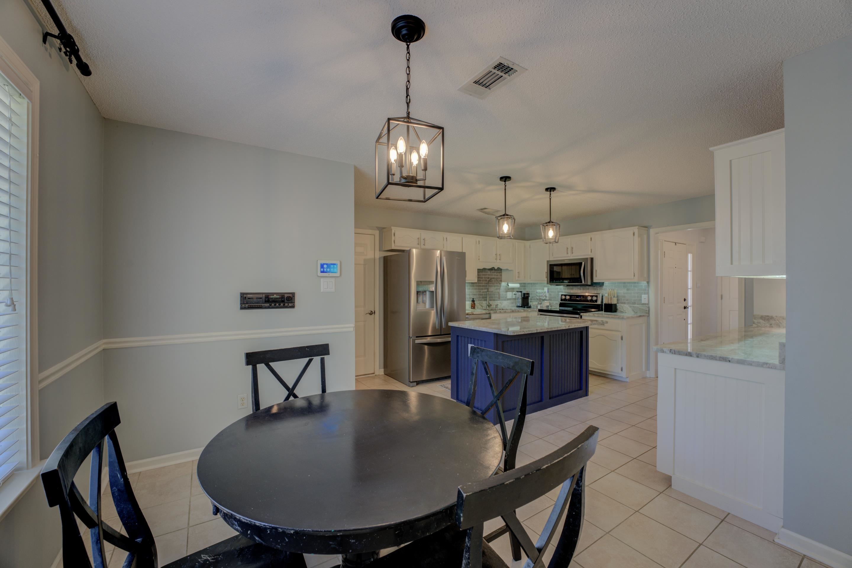 1515 Wolf Pack Drive Collierville, TN 38017 - Photo 15 of 28 a kitchen with stainless steel appliances granite countertop a dining table chairs and chandelier
