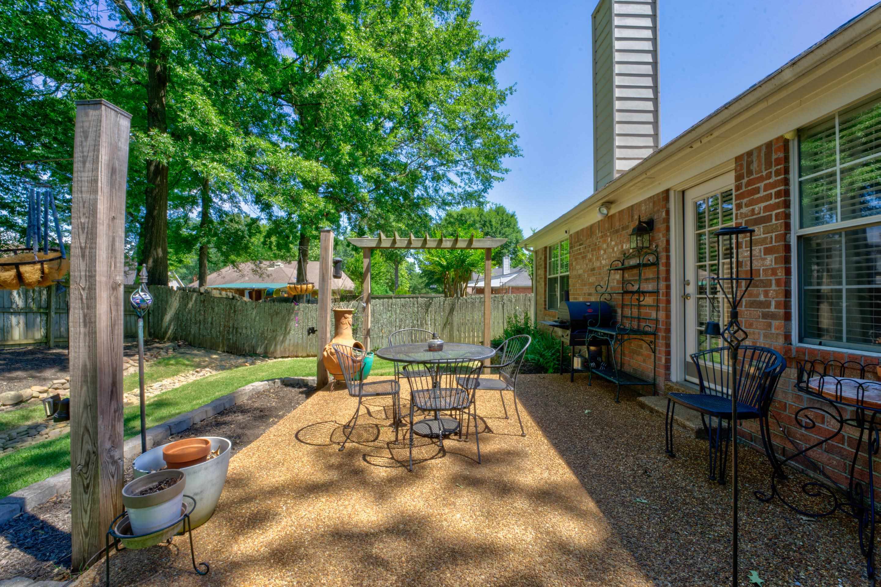 1515 Wolf Pack Drive Collierville, TN 38017 - Photo 25 of 28 a view of a patio with table and chairs potted plants and palm tree