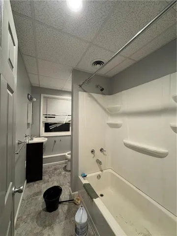 a bathroom with a tub a sink and a shower