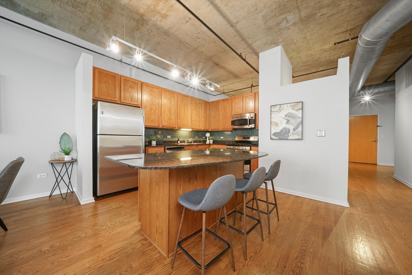 520 South State Street, Unit 503 Chicago, IL 60605 - Photo 10 of 25 a kitchen with stainless steel appliances kitchen island granite countertop a table chairs and a refrigerator