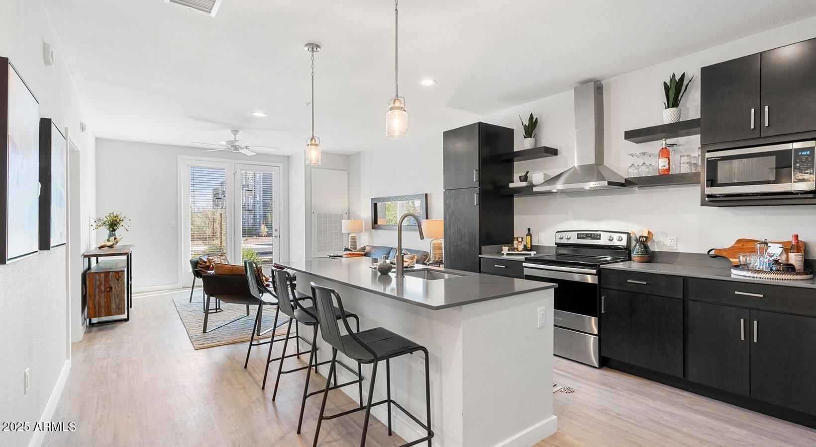 6025 West Thomas Road, Unit 1 Phoenix, AZ 85033 - Photo 6 of 26 a kitchen with stainless steel appliances granite countertop a sink a stove a refrigerator and chairs