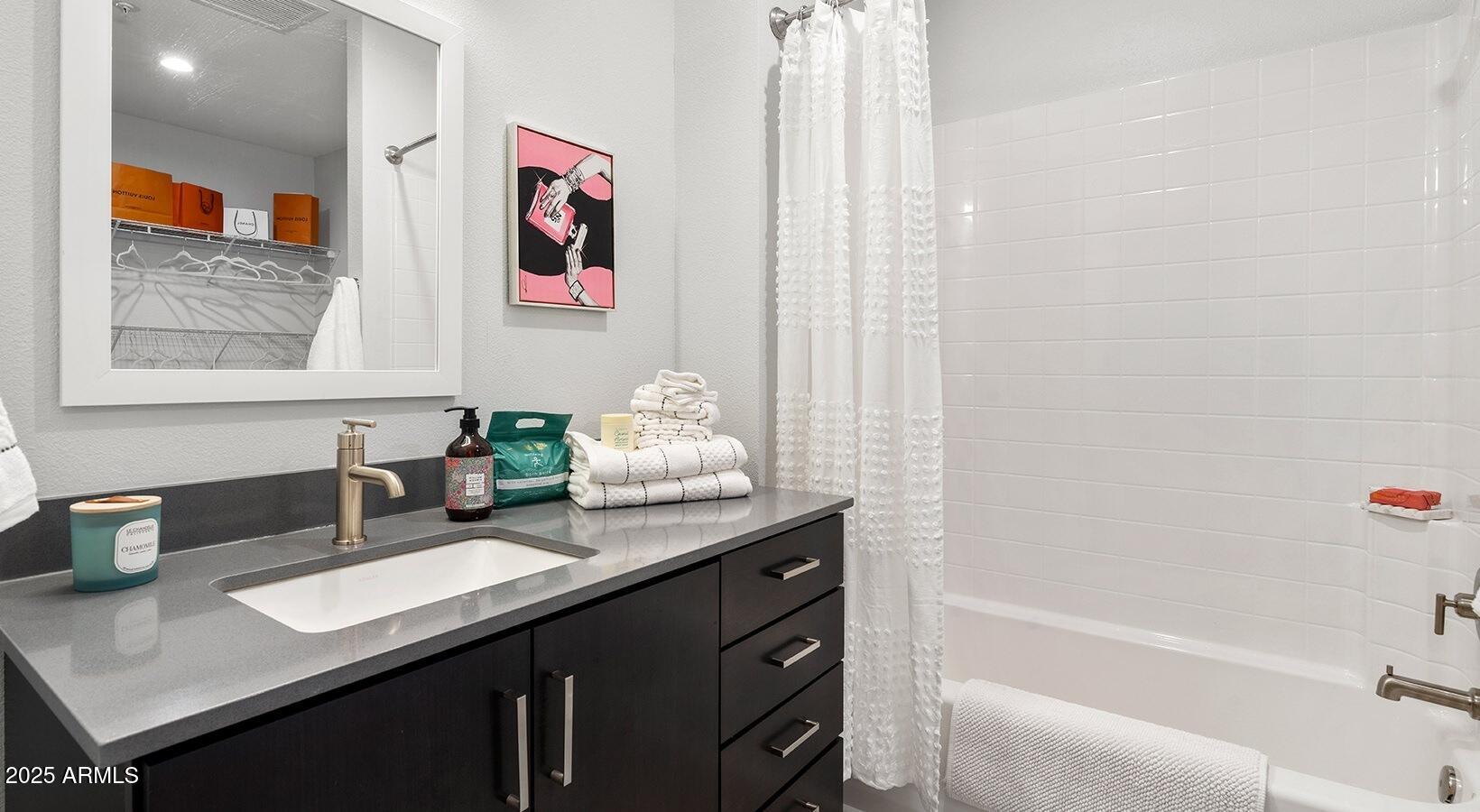 6025 West Thomas Road, Unit 1 Phoenix, AZ 85033 - Photo 8 of 26 a bathroom with a granite countertop sink a mirror a bathtub and shower