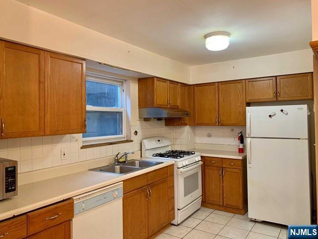 422 A Warren Street, Unit 1F Harrison, NJ 07029 - Photo 2 of 11 a kitchen with a sink a stove and refrigerator