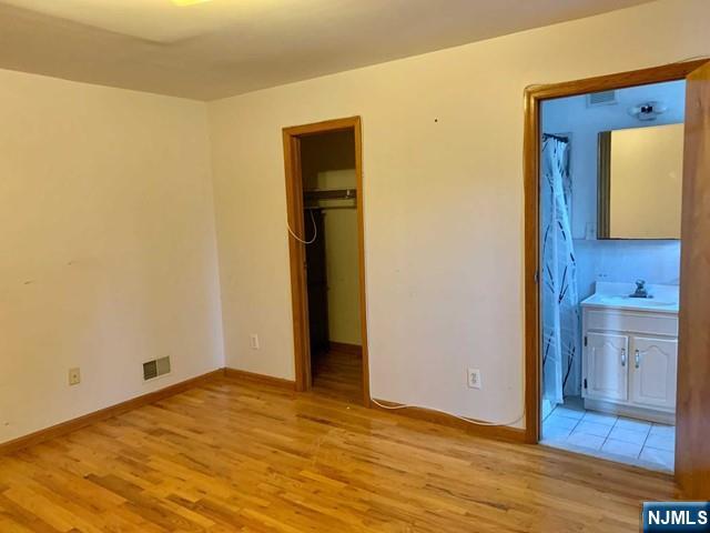 422 A Warren Street, Unit 1F Harrison, NJ 07029 - Photo 8 of 11 a view of empty room with wooden floor and cabinet